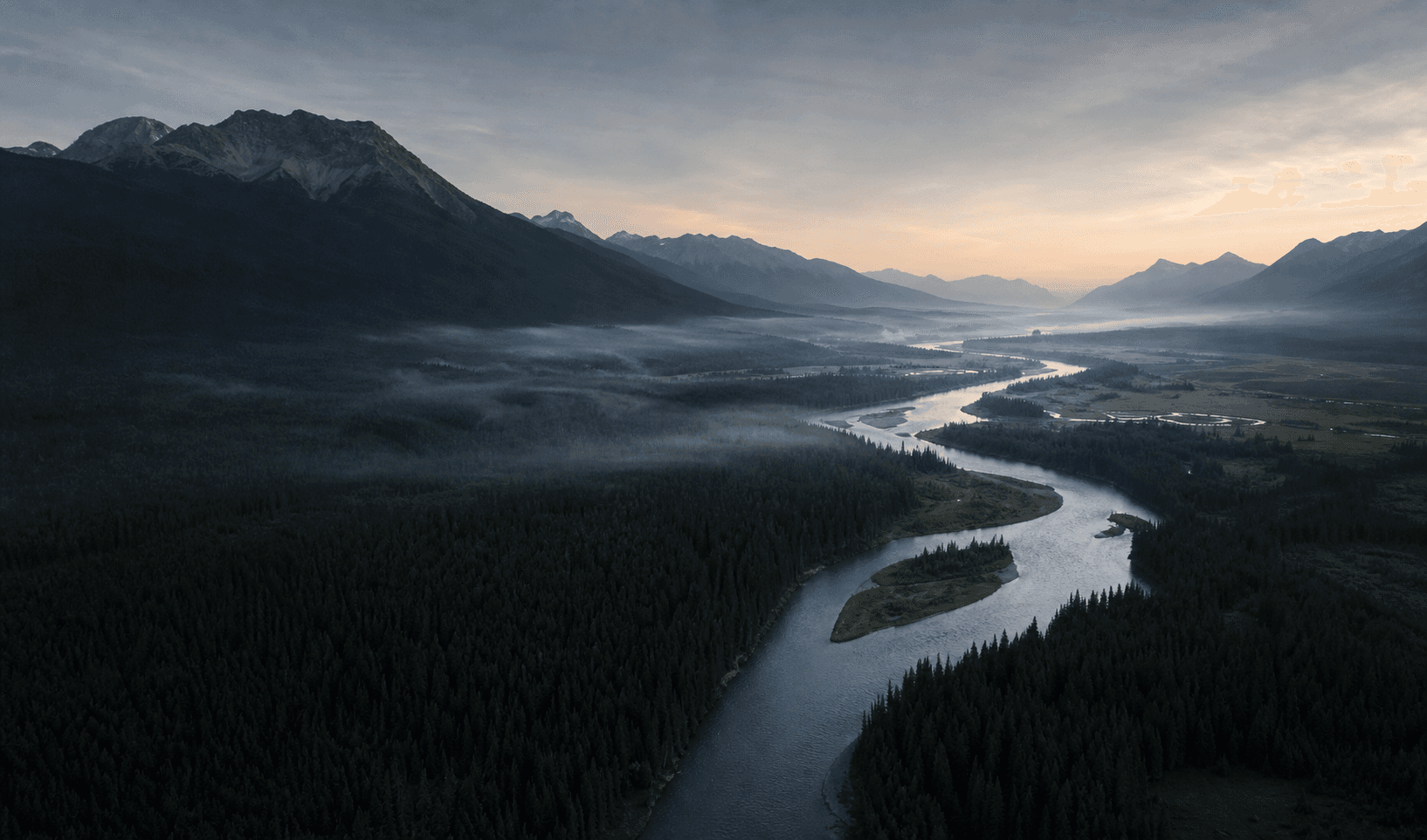 River moving through a wide mountain valley at dawn
